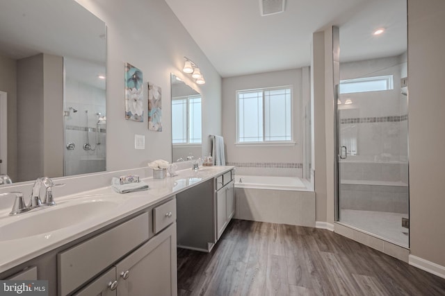 bathroom featuring hardwood / wood-style floors, vanity, and separate shower and tub