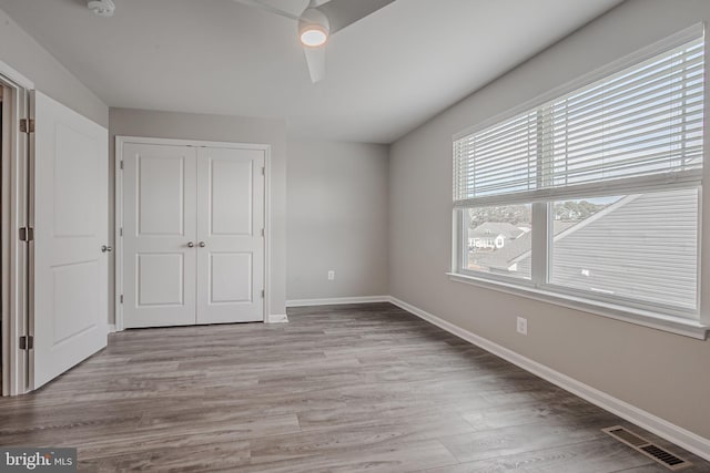 unfurnished bedroom featuring light wood-type flooring, a closet, and ceiling fan