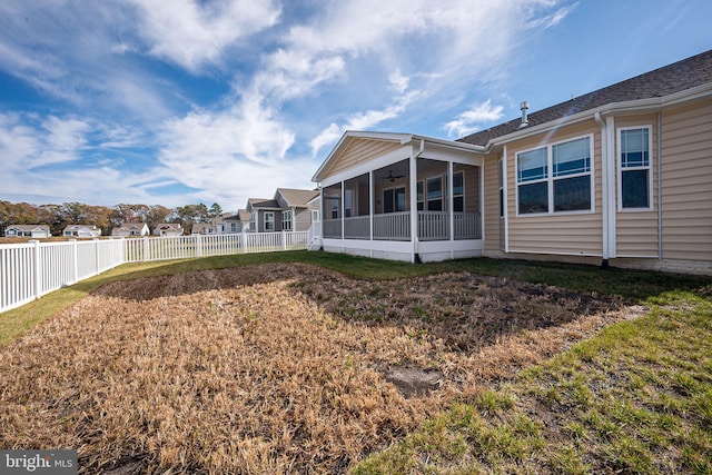 back of property featuring a yard and a sunroom