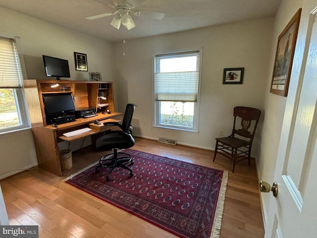 office area with a wealth of natural light, ceiling fan, and light hardwood / wood-style floors