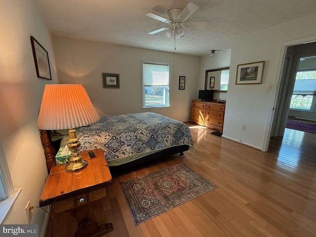 bedroom with hardwood / wood-style floors, a textured ceiling, and ceiling fan