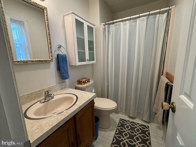 bathroom with walk in shower, vanity, and toilet