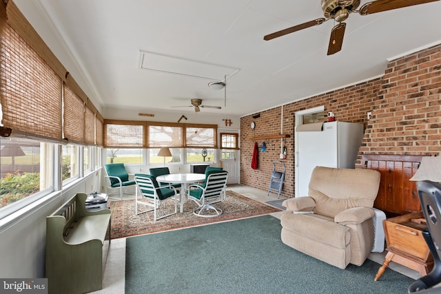 living room with carpet, ceiling fan, and brick wall