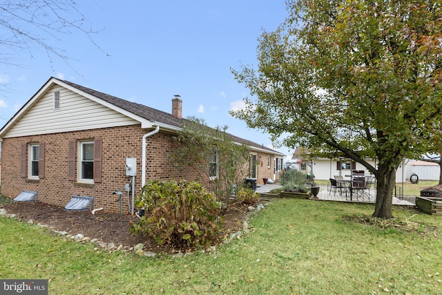 view of property exterior with a lawn and a patio