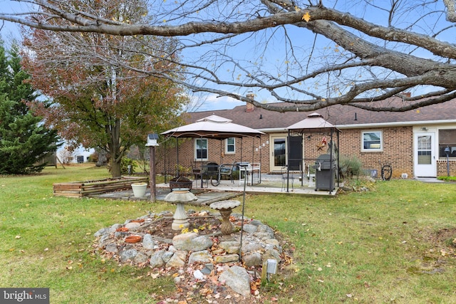 back of house with a gazebo, a patio, and a lawn