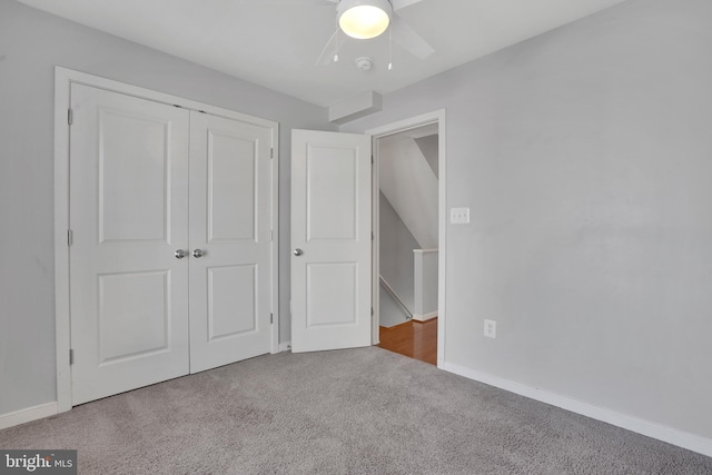 unfurnished bedroom featuring carpet flooring, ceiling fan, and a closet