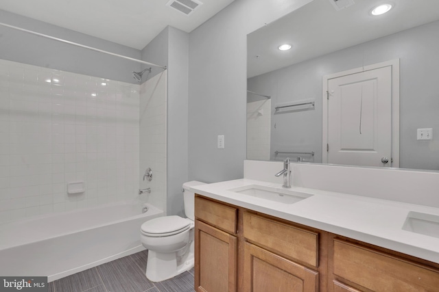 full bathroom with tile patterned floors, tiled shower / bath combo, toilet, and vanity