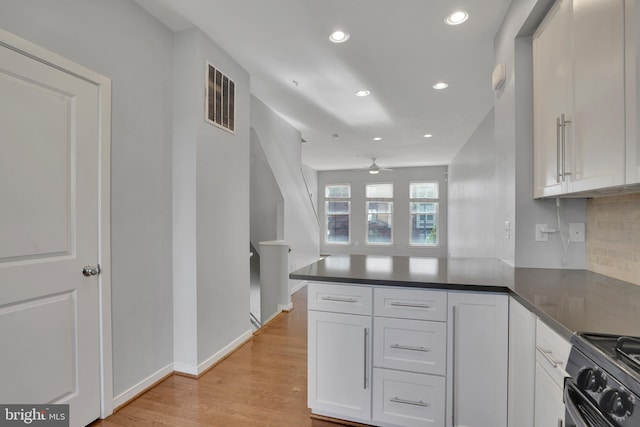 kitchen featuring black / electric stove, white cabinetry, kitchen peninsula, and light hardwood / wood-style flooring