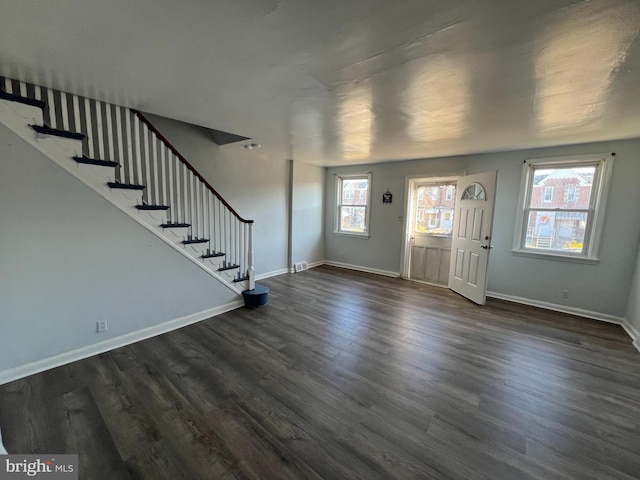 foyer entrance with a healthy amount of sunlight and dark hardwood / wood-style flooring