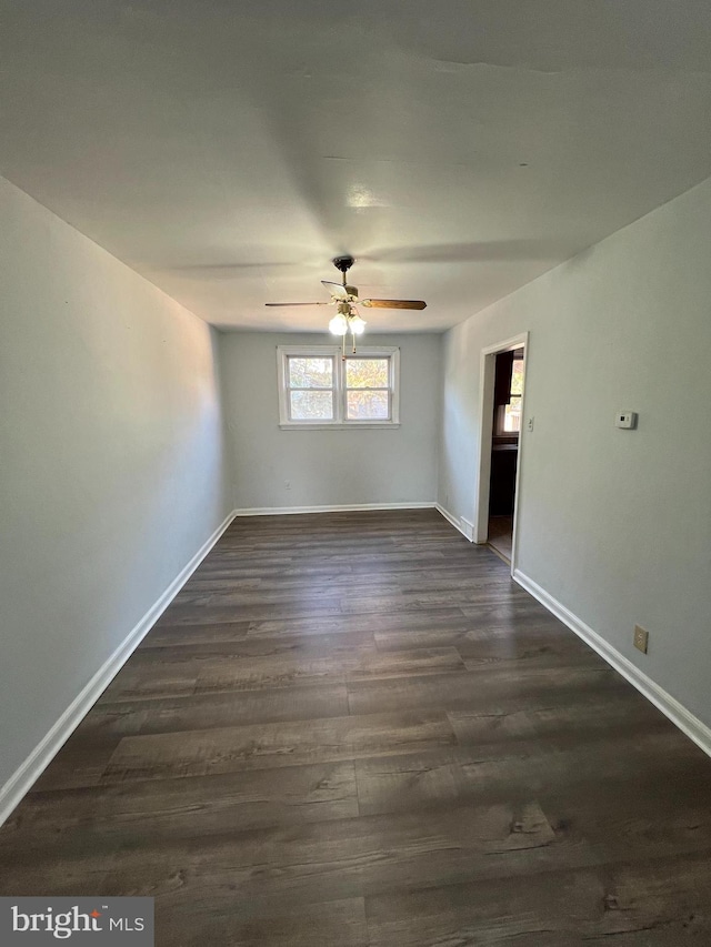 empty room featuring dark hardwood / wood-style flooring and ceiling fan