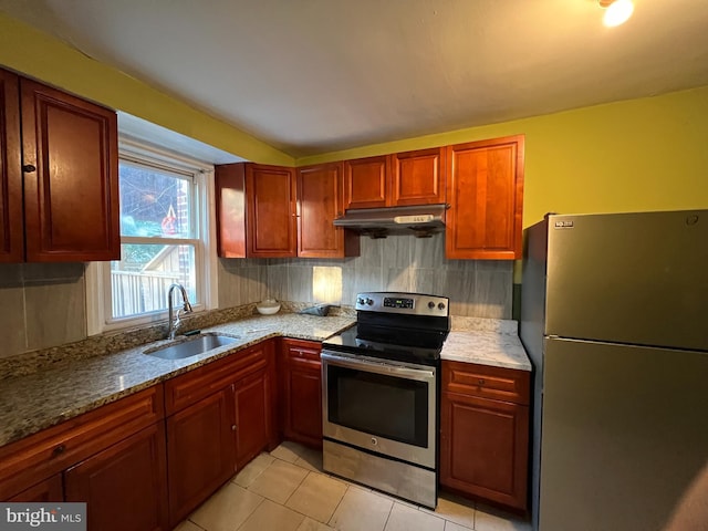 kitchen featuring backsplash, sink, light stone countertops, appliances with stainless steel finishes, and light tile patterned flooring