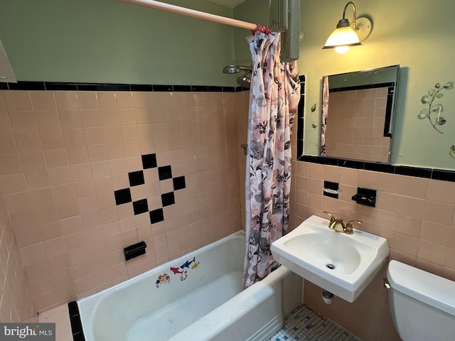 full bathroom featuring sink, tile patterned floors, toilet, shower / tub combo with curtain, and tile walls