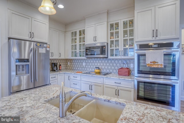 kitchen featuring white cabinetry, ornamental molding, and appliances with stainless steel finishes