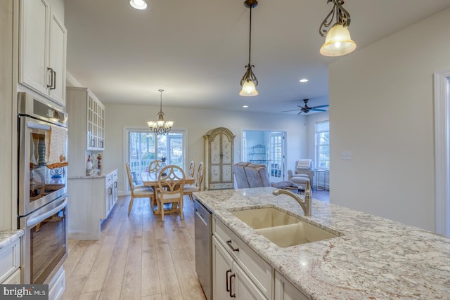 102 Serenity Cir, Middletown, DE 19709 - kitchen with stainless steel appliances, a sink, glass insert cabinets, light wood finished floors, and recessed lighting