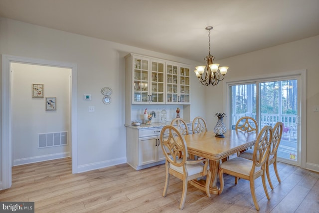 dining room with an inviting chandelier and light hardwood / wood-style flooring