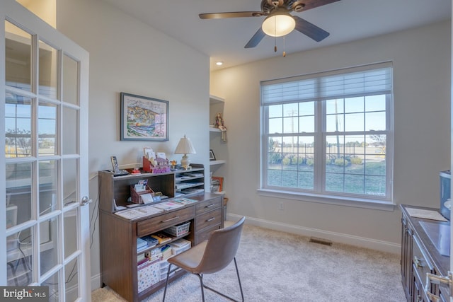 carpeted office space with ceiling fan