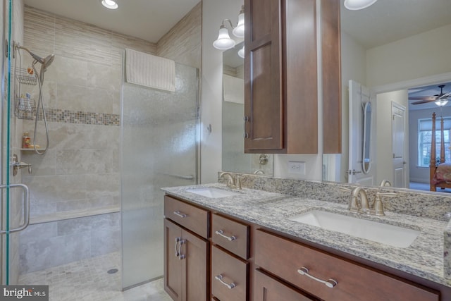 bathroom with vanity, ceiling fan, and a shower with shower door