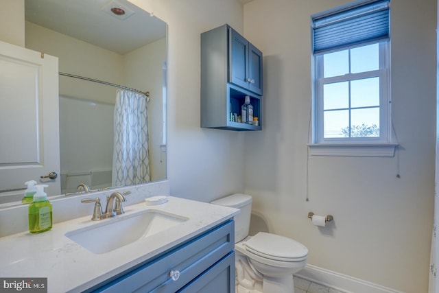 bathroom featuring curtained shower, tile patterned flooring, vanity, and toilet