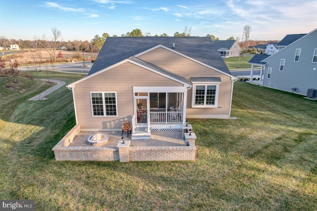 back of property featuring central AC unit, a sunroom, and a yard