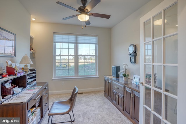 home office featuring light carpet and ceiling fan