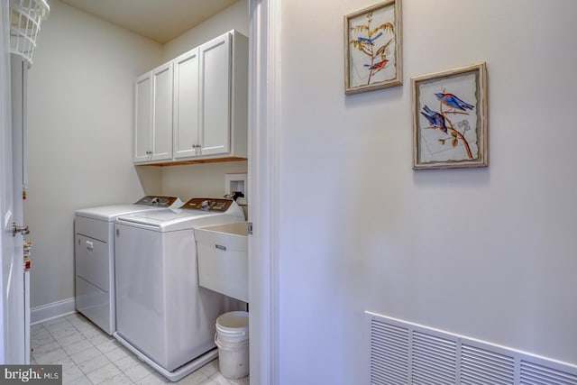 laundry room featuring washer and clothes dryer and cabinets