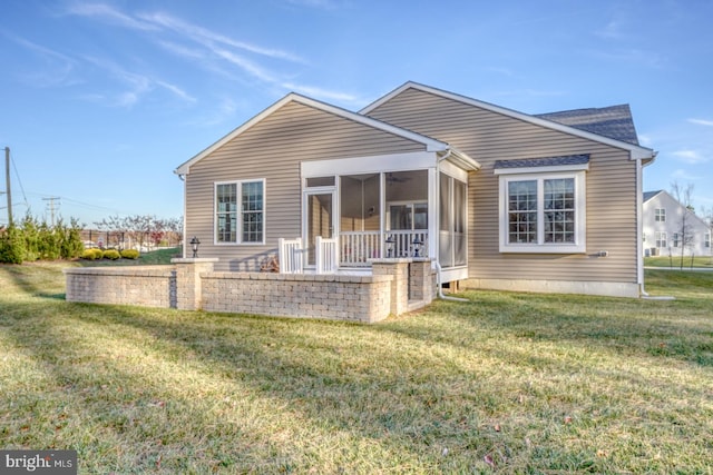 rear view of house featuring a sunroom and a yard