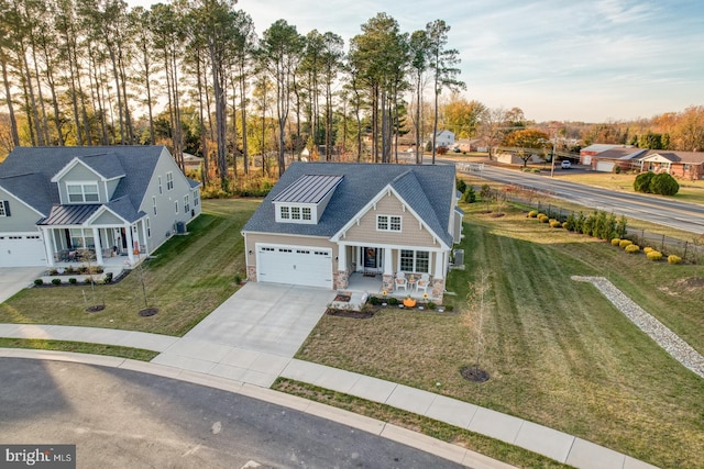 view of front facade with a front yard, a porch, and a garage