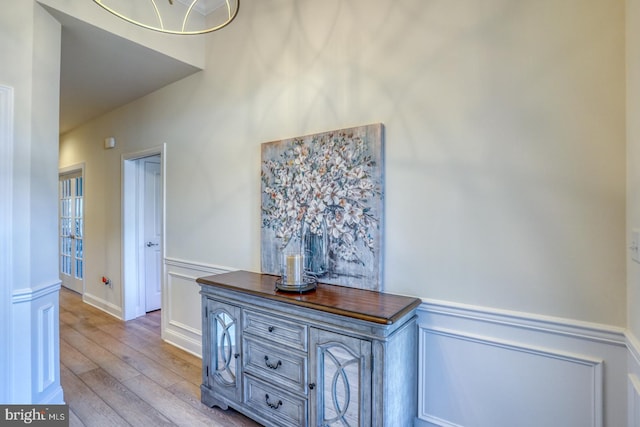 hallway featuring light wood-type flooring and an inviting chandelier