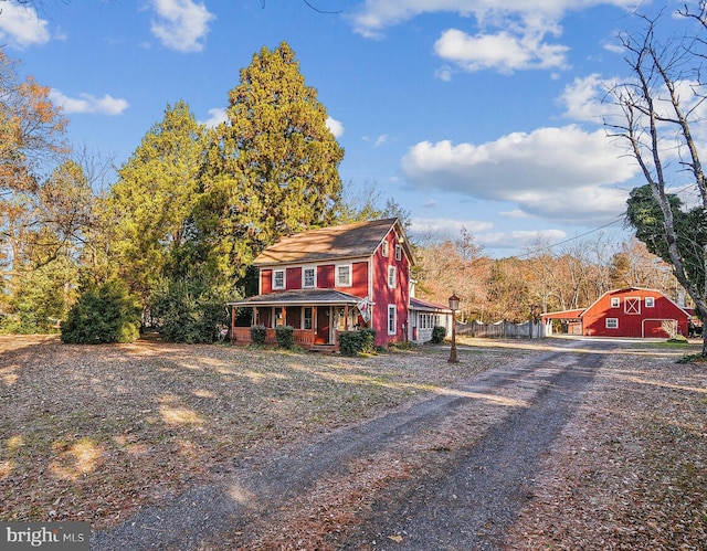 4555 Snow Hill Rd, Salisbury, MD 21804 - colonial-style house with a barn, dirt driveway, a porch, and an outdoor structure