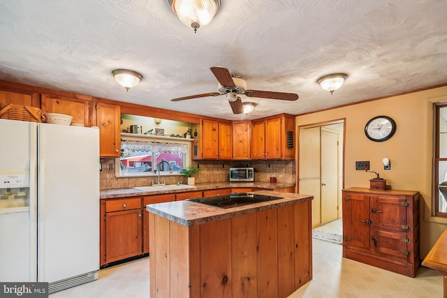 kitchen with a center island, white refrigerator with ice dispenser, backsplash, sink, and black electric cooktop