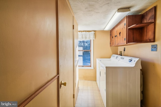 washroom featuring washer and clothes dryer and cabinets