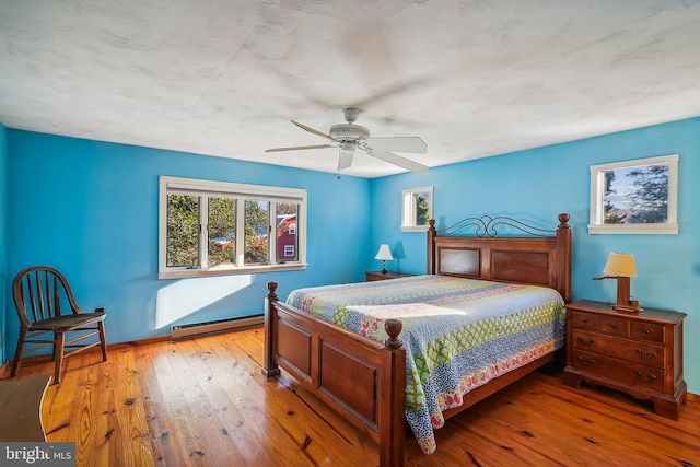 bedroom with light wood-type flooring, a baseboard radiator, and ceiling fan