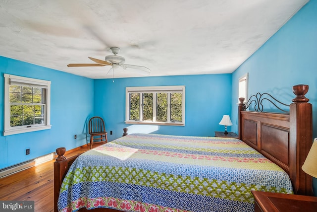 bedroom featuring ceiling fan, wood-type flooring, and a baseboard radiator