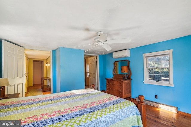 bedroom with baseboard heating, ceiling fan, a wall unit AC, and wood-type flooring