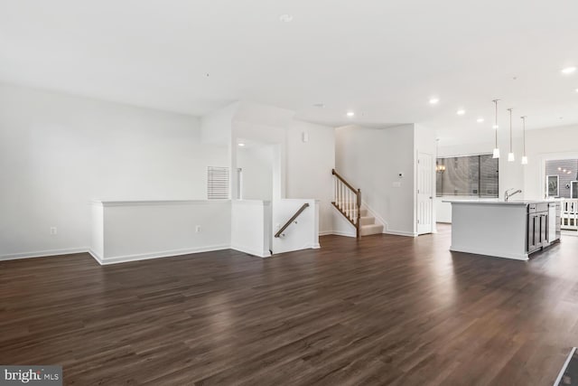 unfurnished living room featuring dark hardwood / wood-style flooring and sink