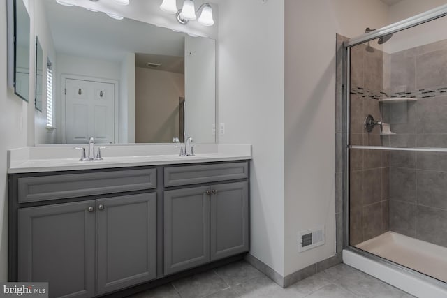 bathroom featuring tile patterned flooring, vanity, and an enclosed shower