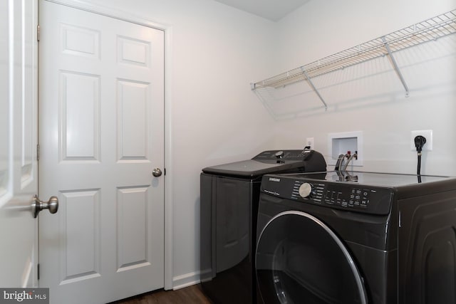 laundry area with dark hardwood / wood-style flooring and separate washer and dryer