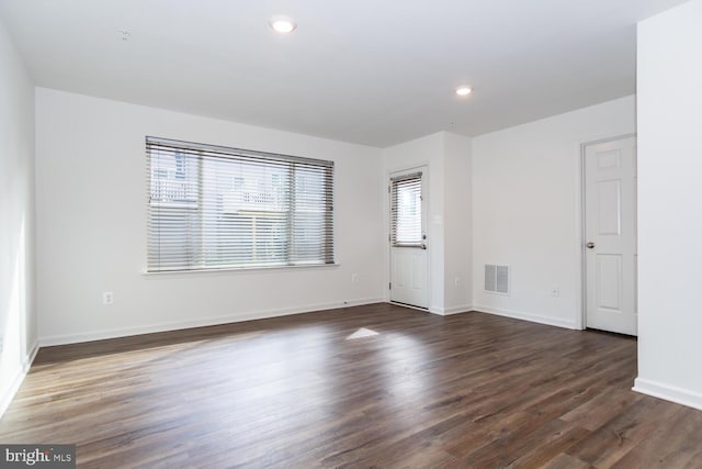 empty room with dark hardwood / wood-style flooring