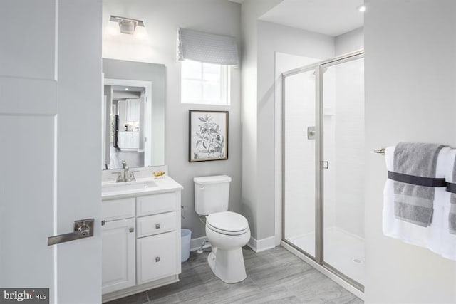 bathroom with vanity, toilet, and a shower with shower door