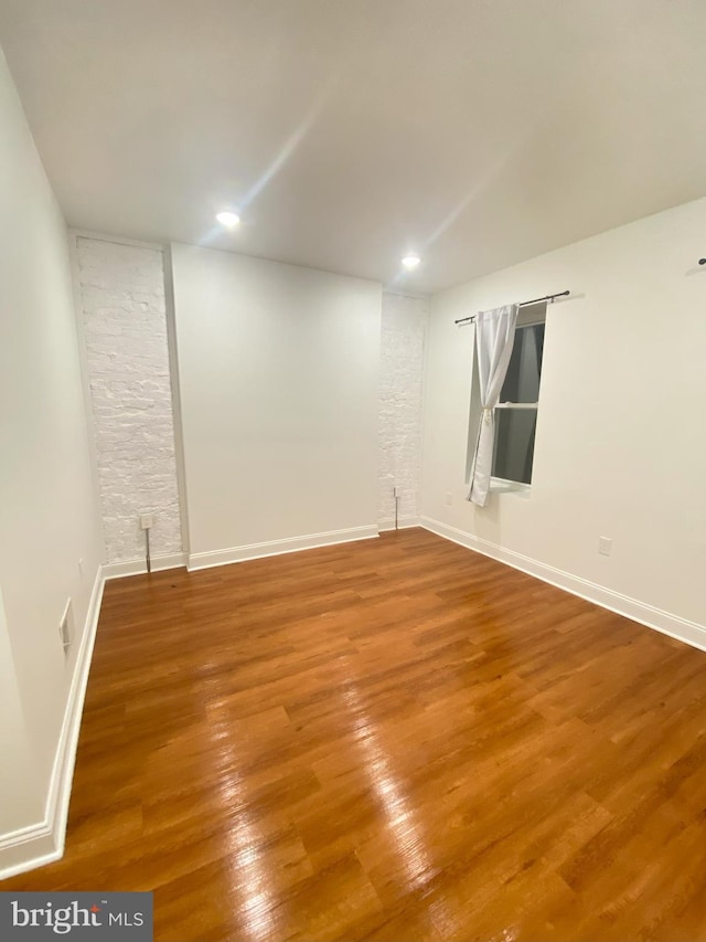 spare room featuring wood-type flooring