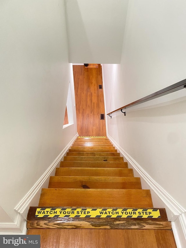 staircase with hardwood / wood-style flooring