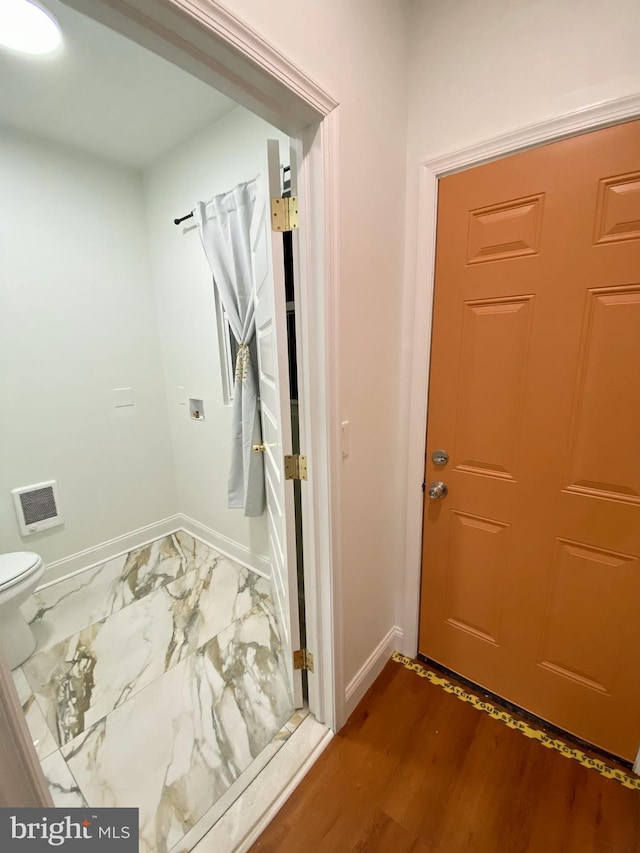 bathroom featuring hardwood / wood-style flooring and toilet