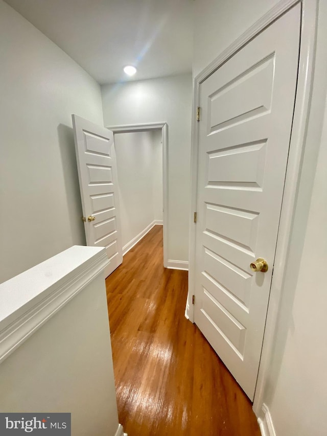 corridor with hardwood / wood-style floors