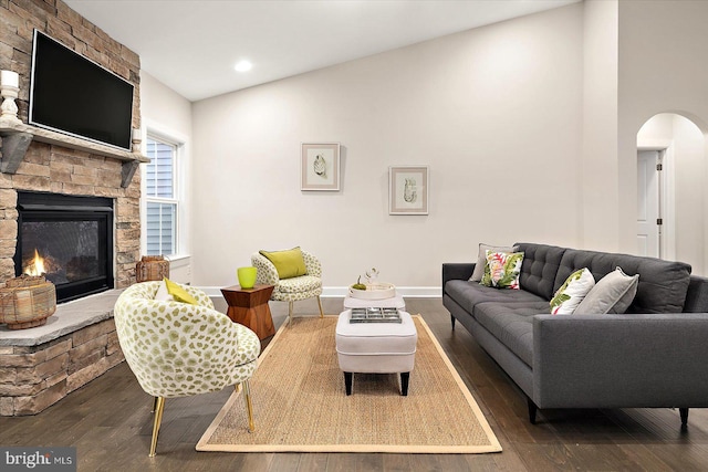 living room featuring a fireplace, dark hardwood / wood-style floors, and vaulted ceiling