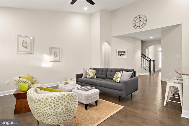 living room with ceiling fan, high vaulted ceiling, and dark wood-type flooring