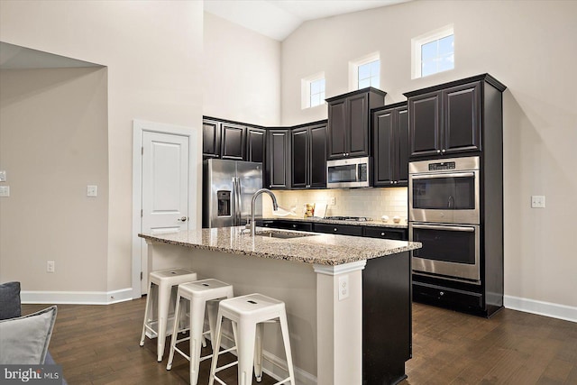 kitchen with dark hardwood / wood-style flooring, sink, an island with sink, and stainless steel appliances