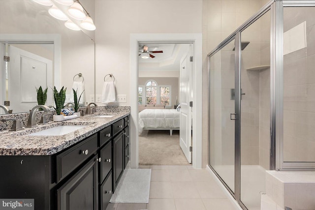 bathroom with vanity, a raised ceiling, tile patterned flooring, ceiling fan, and walk in shower