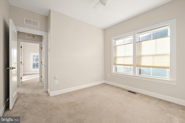 spare room featuring ceiling fan and light colored carpet