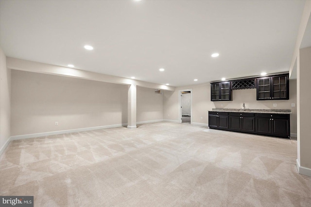 basement featuring indoor wet bar and light carpet