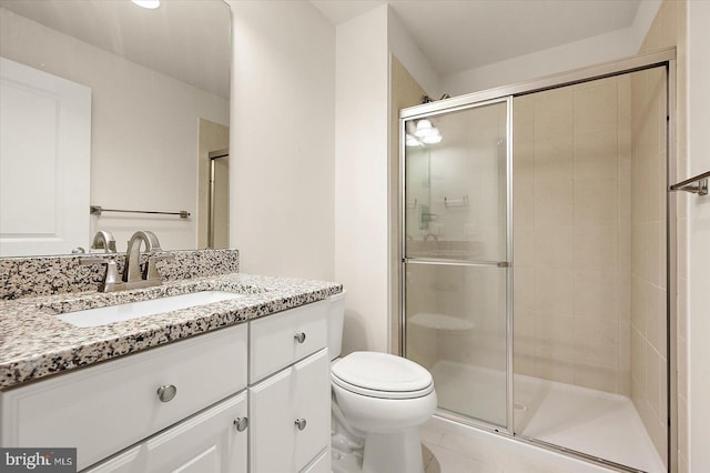 bathroom with tile patterned flooring, vanity, an enclosed shower, and toilet